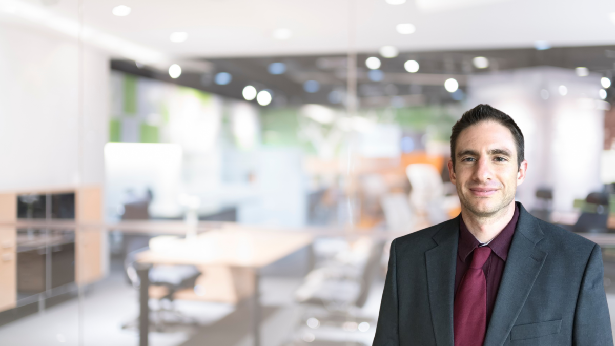 Confident professional standing in a modern office space.