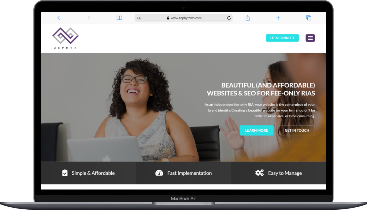 A person smiling at their laptop screen with a website for seo and website services displayed on it.