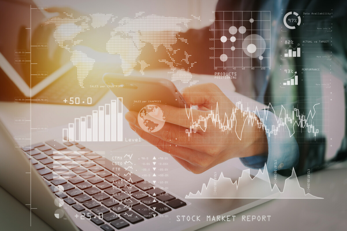 Global finance at your fingertips: a professional analyzing stock market trends on a smartphone with digital financial graphs overlaid.