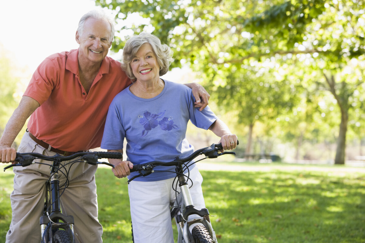 Senior couple enjoying a sunny day in the park with their bicycles.