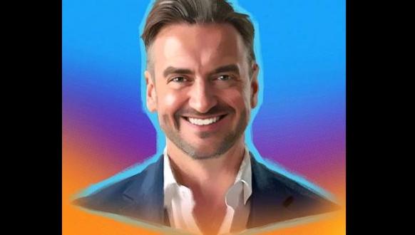 A smiling man in a blazer and white collared shirt against a vibrant, multi-colored background.